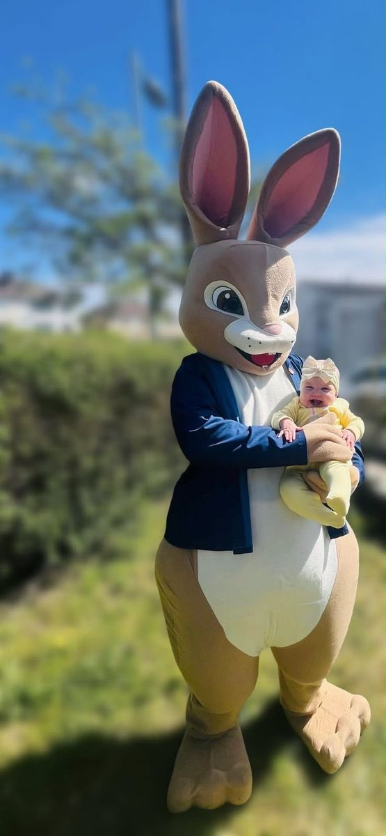 The Easter Bunny holding a baby in the sunshine
