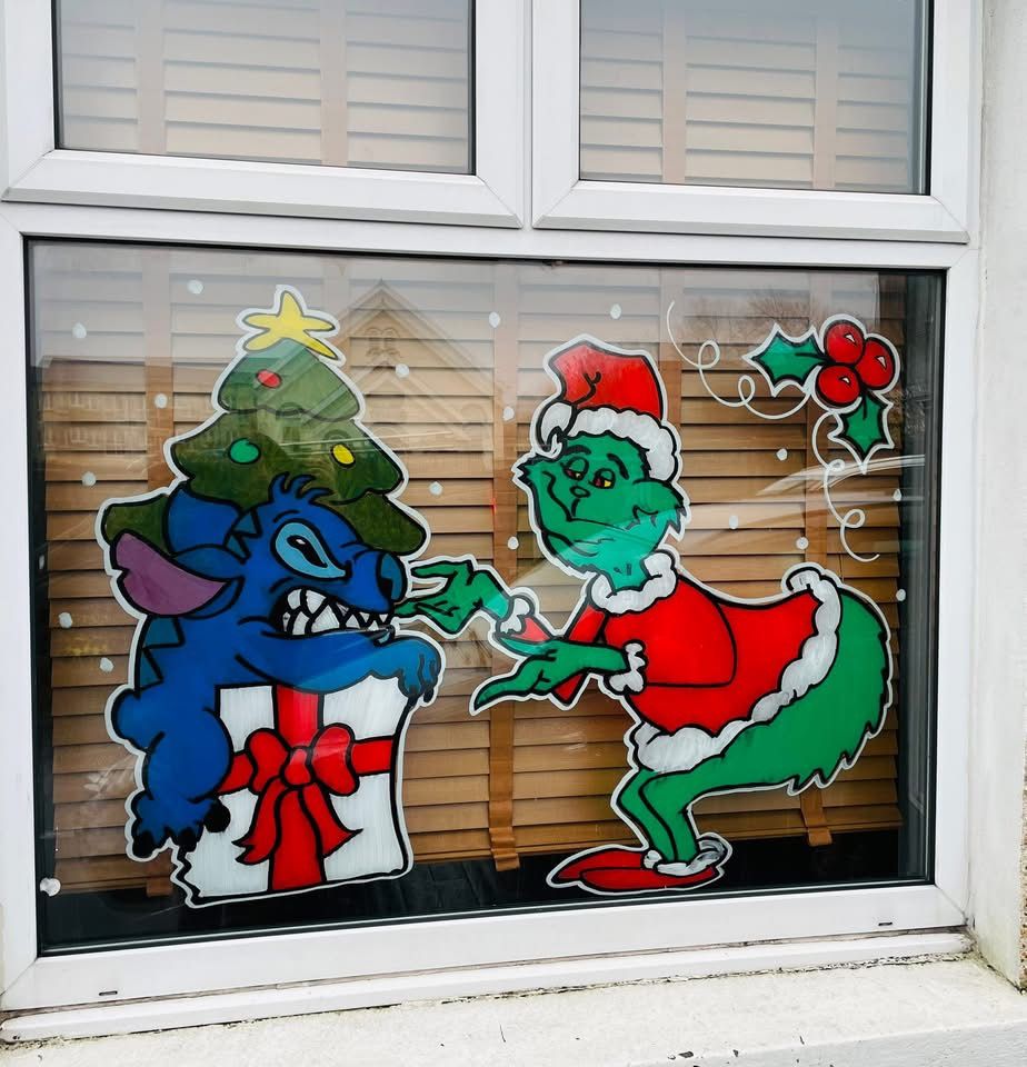 Two cartoon characters fighting over a Christmas present, painted on a window